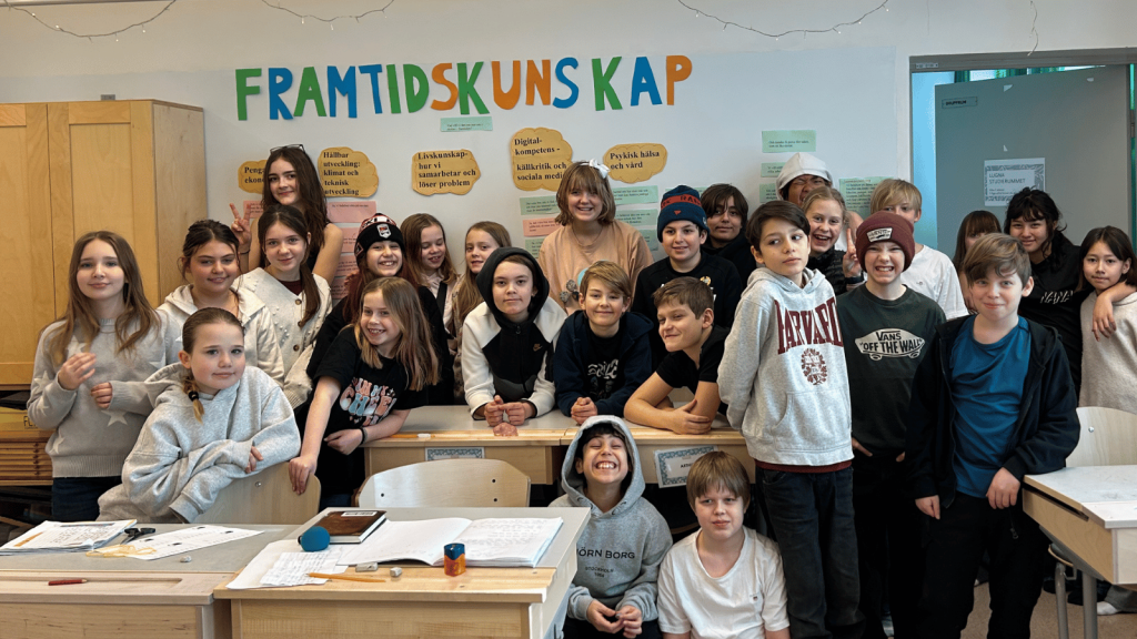 Klasskompisar som ler för klassfoto i ett klassrum